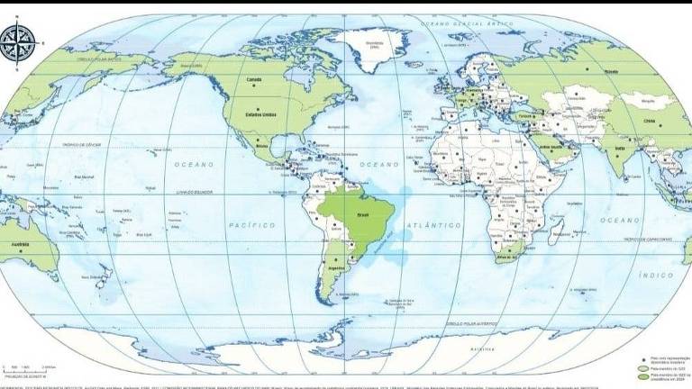 Mapa mundi mostrando todos os continentes e oceanos, mas com o Brasil no centro da projeção. Alguns países estão destacados em verde, incluindo Canadá, Estados Unidos, Brasil, Rússia, China, Índia e Austrália. O mapa inclui linhas de latitude e longitude, além de uma rosa dos ventos no canto superior esquerdo.