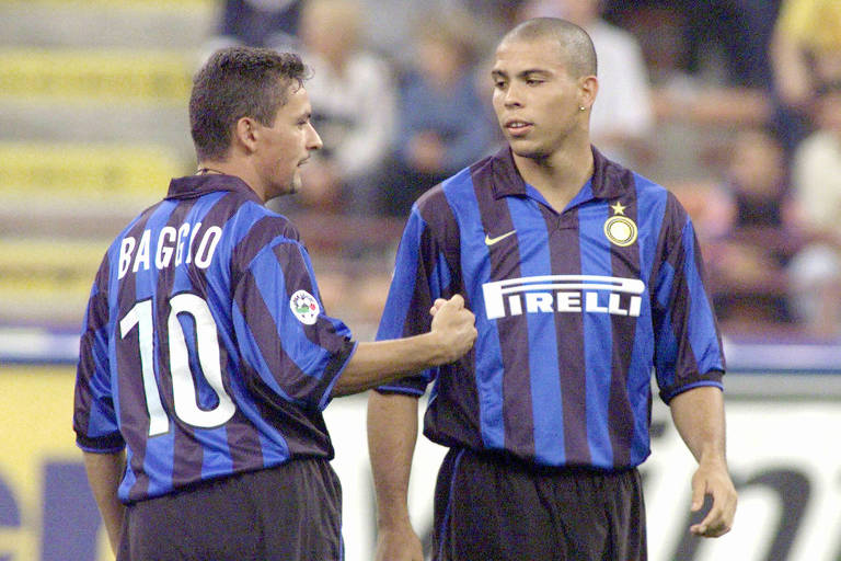 A imagem mostra dois jogadores de futebol do Inter de Milão em campo. O jogador à esquerda está de costas, com o nome 'Baggio' e o número 10 em sua camisa. Ele está gesticulando com a mão direita. O jogador à direita está de frente, com a camisa do Inter de Milão, que tem listras azuis e pretas e o logotipo da Pirelli.