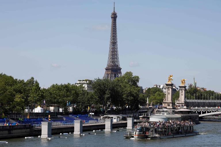 Barco de turistas cruza o rio Sena nas proximidades da Torre Eiffel, em Paris