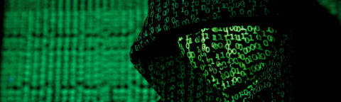 FILE PHOTO: A projection of cyber code on a hooded man is pictured in this illustration picture taken on May 13,  2017. Capitalizing on spying tools believed to have been developed by the U.S. National Security Agency, hackers staged a cyber assault with a self-spreading malware that has infected tens of thousands of computers in nearly 100 countries. REUTERS/Kacper Pempel/Illustration//File Photo ORG XMIT: FW1