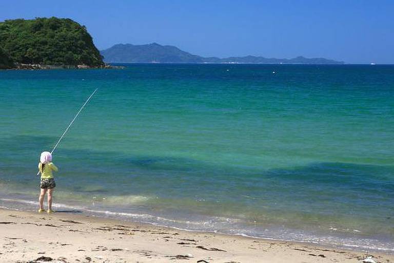 Mulher pescando na praia de Fukutsu