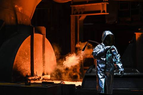 (FILES) An employee takes a sample at the blast furnace at the ThyssenKrupp plant in Duisburg, western Germany on November 16, 2021. German industrial giant Thyssenkrupp reported a massive annual loss on November 22, 2023 due to surging costs, as talks about a tie-up of its steel division with Czech billionaire Daniel Kretinsky's energy company continue. Its steel division, Steel Europe, has been suffering in recent years, due to low prices and competition from Asian countries. (Photo by Ina FASSBENDER / AFP)