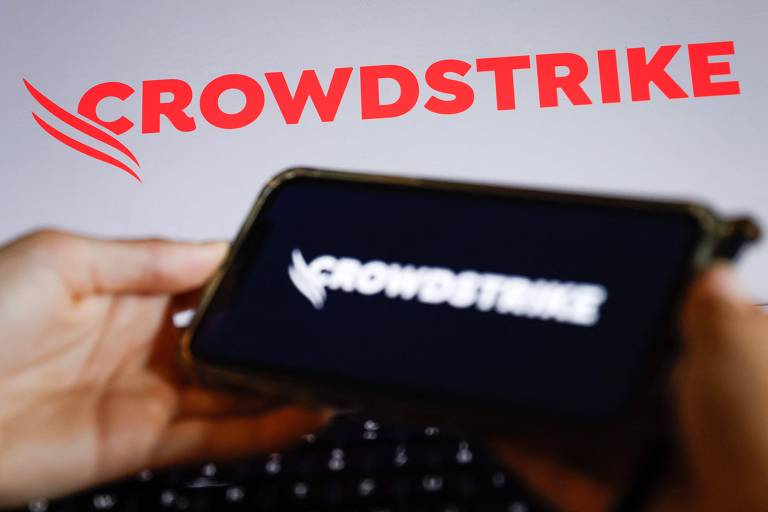 Fotografia ilustrativa mostra smartphone com logo da Crowdstrike desfocado, em primeiro plano, à frente de versão vermelha do logo da empresa