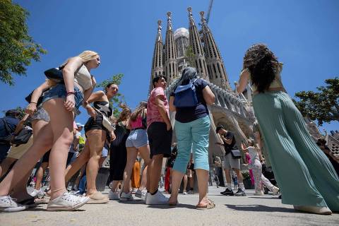 Tourists stand in front of the Sagrada Familia basilica in Barcelona on July 5, 2024. (Photo by Josep LAGO / AFP)