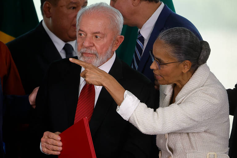 Lula ao lado de Marina, que aponta para o lado