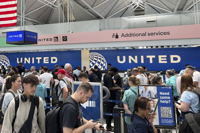 Passageiros em fila no Aeroporto Internacional de Chicago, nos Estados Unidos, durante a sexta-feira (19), dia do apagão cibernético global