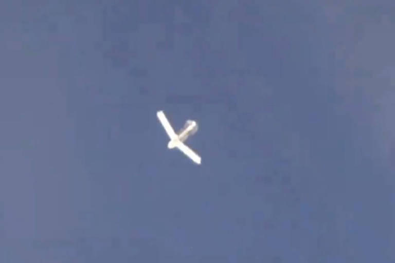 Imagem mostra bomba branca com asas abertas num céu azul