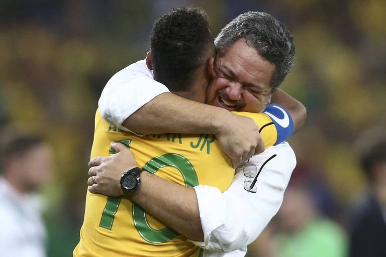 Com os olhos fechados e emocionado, Rogério Micale, treinador do Brasil na Rio 2016, abraça Neymar, que usa a camisa 10 e está de costas, depois da conquista da medalha de ouro no Maracanã 