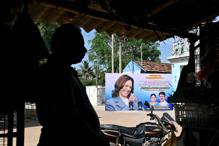 Homem passa por pôster da vice-presidente dos EUA, Kamala Harris, em sua aldeia ancestral de Thulasendrapuram, no estado de Tamil Nadu, no sul da Índia