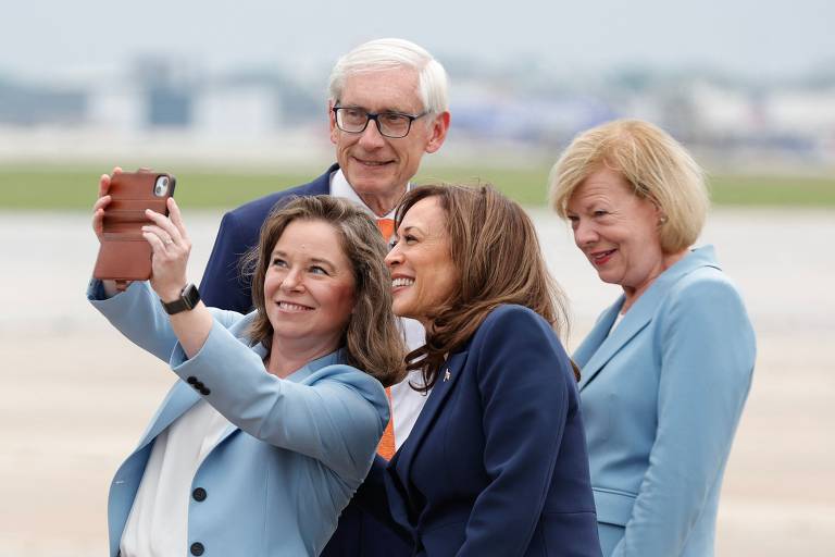 Kamala posa para selfie ao lado da vice-governadora de Wisconsin, Sara Rodriguez, enquanto as duas são observadas pelo governador de Wisconsin, Tony Evers, e pela senadora democrata Tammy Baldwin