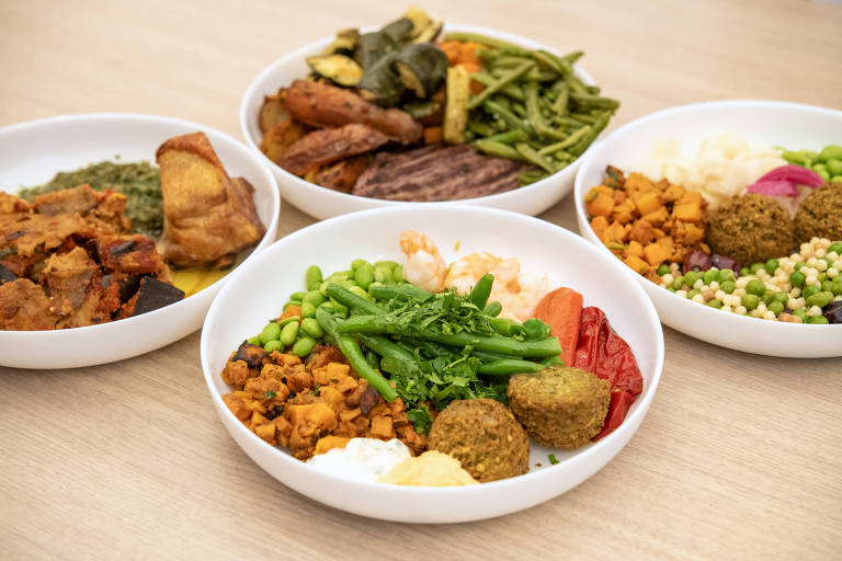 Quatro pratos brancos com legumes, verduras e carnes 