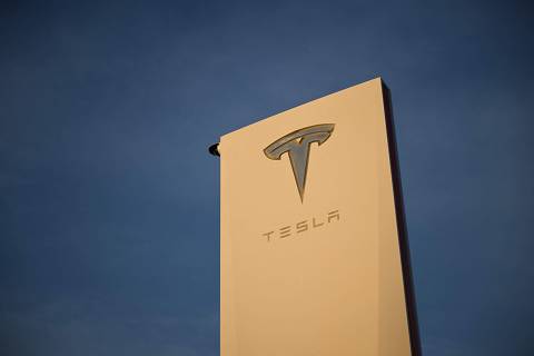 (FILES) The Tesla, Inc. logo is displayed on a sign outside the Tesla Design Center in Hawthorne, California, on August 9, 2022. Tesla reported a hefty drop in second-quarter profits on July 23, 2024 due to the effect of price cuts while spending aggressively on artificial intelligence and other technology. Elon Musk's electric vehicle company reported profits of $1.5 billion, down 45 percent, on revenues of $25.5 billion, up two percent. (Photo by Patrick T. FALLON / AFP)