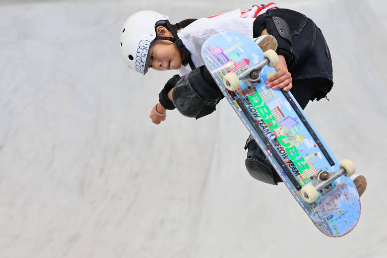 Usando capacete da cor branca, a chinesa Zheng Haohao, 11, que estará nas Olimpíadas de Paris, faz manobra com seu skate em competição em Xangai