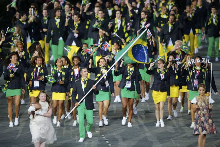 O porta-bandeira do Brasil, Rodrigo Pessoa (C), segura a bandeira nacional enquanto lidera o contingente no desfile de atletas durante a cerimônia de abertura dos Jogos Olímpicos de Londres 2012, no Estádio Olímpico