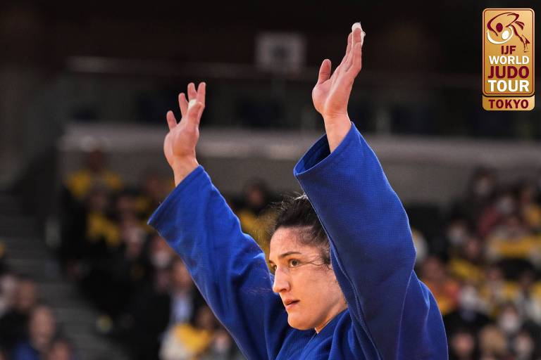 Usando quimono azul, a judoca faixa preta Mayra Aguiar ergue os braços depois de luta no Grand Slam de Tóquio, em 2023