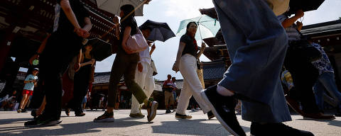 Passersby holding umbrellas walk under a strong sunlight at the Sensoji temple as Japanese government issued heat stroke alerts in 39 of the country's 47 prefectures in Tokyo, Japan July 22, 2024.  REUTERS/Issei Kato ORG XMIT: GGGTOK601