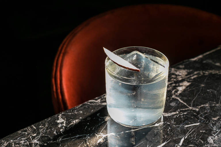 Drinque transparente em mesa de mármore em copo baixo