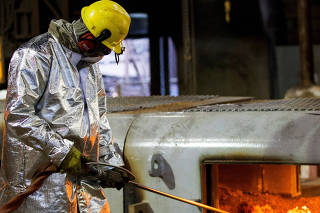 FILE PHOTO: An enployee works in the Brazilian steelmaker Usiminas blast furnace after a long shutdown, in Ipatinga
