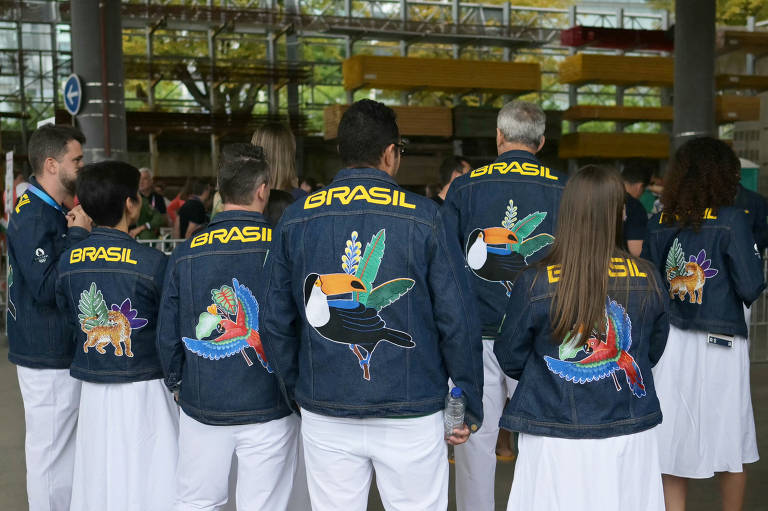 Membros da delegação brasileira se preparam para entrar no barco onde irão participar da cerimônia