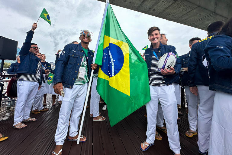 Isaquias Querioz, da canoagem, e Raquel Kochhann, do rúgbi, porta-bandeiras do Brasil na cerimônia de abertura das Olimpíadas de Paris-2024, no barco que levou a delegação pelo rio Sena