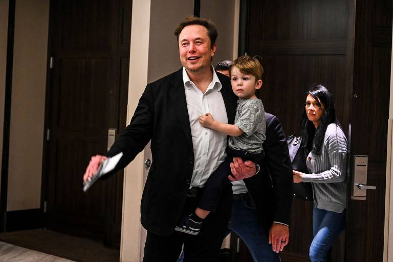 O CEO do Twitter, Elon Musk, segura um de seus filhos após um discurso principal na conferência de marketing Twitter 2.0 em Miami Beach, Flórida