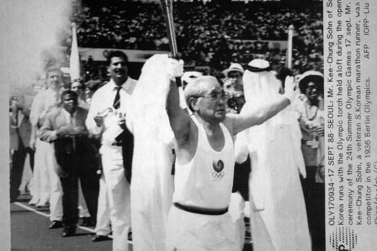 Maratonista sul-coreano Kee-Chung Sohn, que competiu Berlim-1936, com a tocha olímpica na cerimônia de abertura de Seul-1988. Naquela edição, a pira foi acesa por Sun-man Chung, Mi-Chung Sohn e Won-Tak Kim