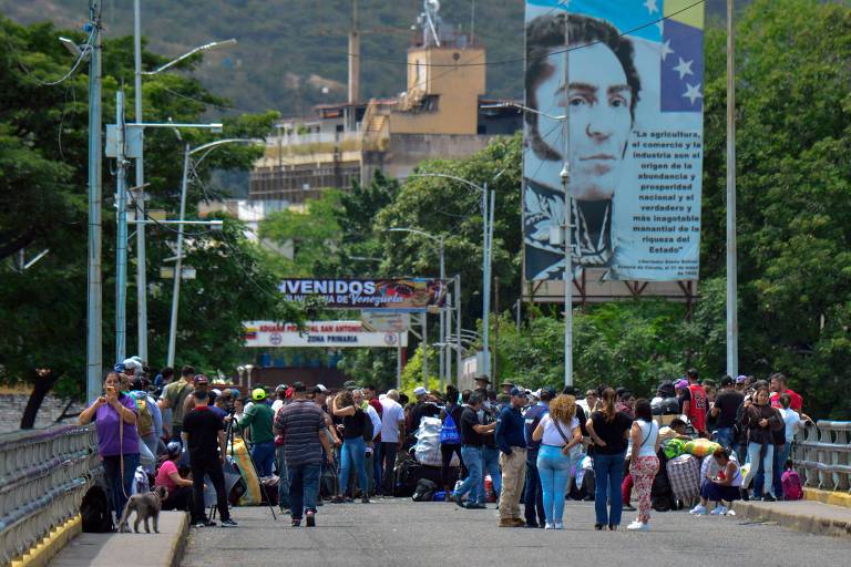 Cidadãos se aglomeram ao redor de membros da Guarda Nacional Bolivariana na ponte Simon Bolívar após fronteira terrestre Colômbia-Venezuela ter sido fechada, em Villa del Rosario; fronteiras aéreas venezuelanas seguem abertas