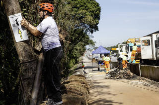 Rota ciclistica Marcia Prado, que liga a zona sul paulista ao litoral, sera liberada para ciclistas dia 28: Andre Pasqualini,50 (ativista e participador do coletivo DBM, Desafio Bicicletas ao Mar) instala placas de orientacao da rota Marcia Prado em trecho em obras da ciclovia (altura do km 38) na  Rodovia dos Imigrantes