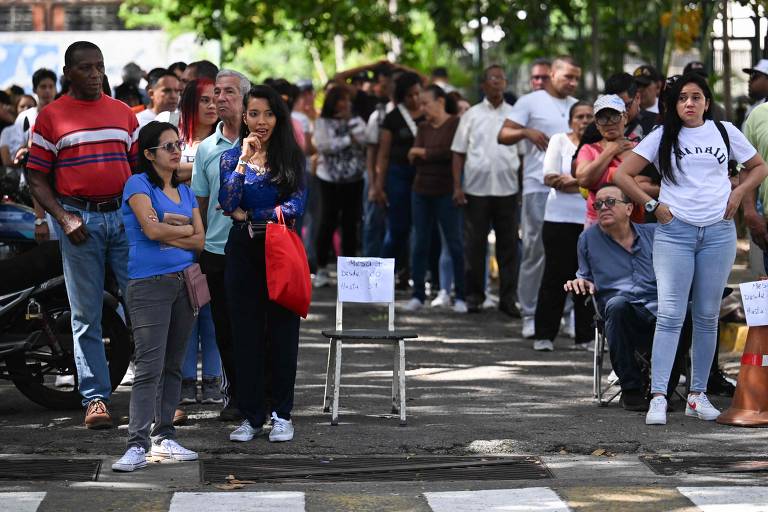 Eleitores fazem fila para votar na eleição presidencial em Caracas, neste domingo (28)