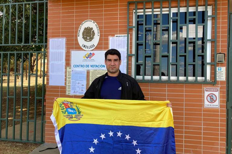 Homem segura bandeira da Venezuela em frente à embaixada
