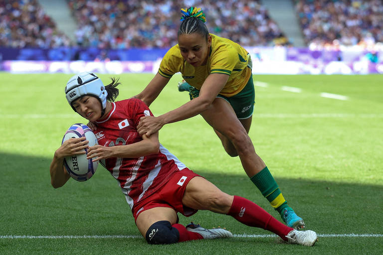 A japonesa Honoka Tsutsumi supera marcação de jogadora brasileira para fazer um "try" em partida de rúgbi sete nas Olimpíadas de Paris