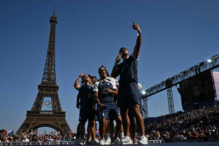 Time francês de rúgbi sevens, campeões da modalidade masculina, tira selfie com suas medalhas e Torre Eiffel ao fundo