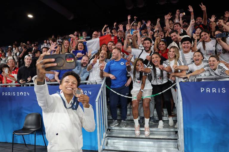 Medalhista de bronze na categoria peso meio-leve, a francesa Amandine Buchard posa para foto com o público, na Arena Campo de Marte, em Paris