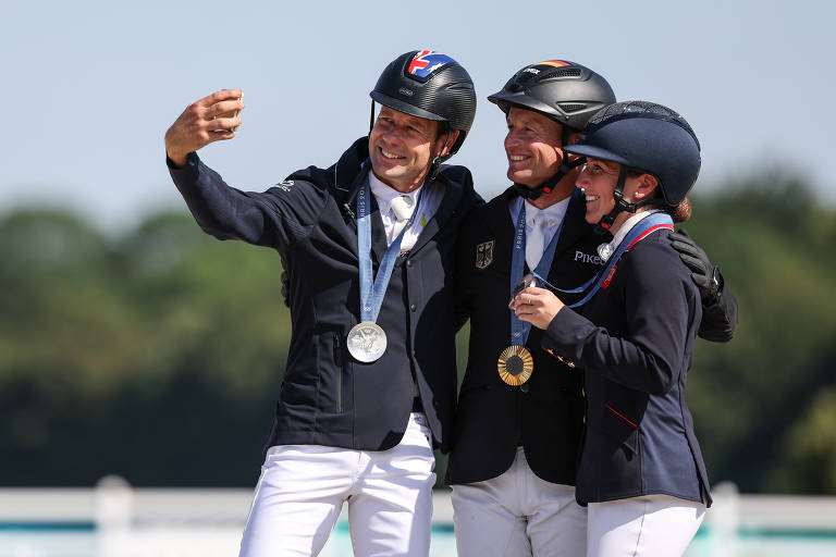 Os cavaleiros Michael Jung, da Alemanha, Christopher Burton, da Austrália, e Laura Collett, da Grã-Bretanha, posam para foto com suas medalhas pelo salto individual