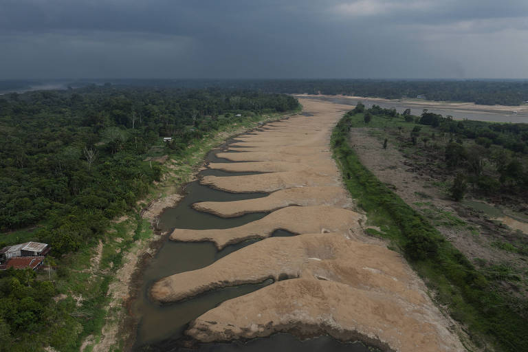 Vista de drone de rio quase seco, apenas com areia em quase a sua totalidade, cercado com margens com floresta