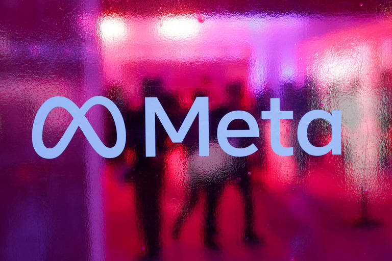 A imagem mostra o logotipo da Meta, que consiste em um símbolo de infinito ao lado da palavra 'Meta'. O fundo é de um vidro texturizado que reflete luzes em tons de rosa e roxo, criando um efeito visual vibrante. Silhuetas de pessoas podem ser vistas ao fundo.
