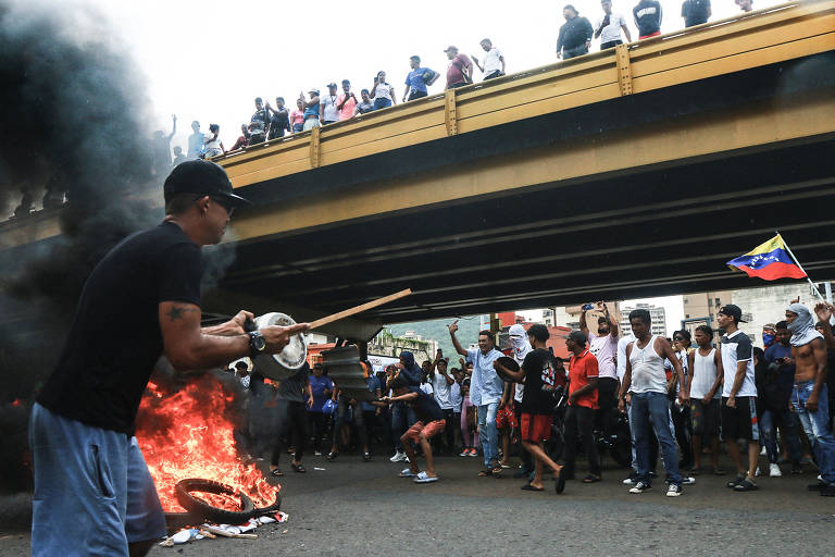 Manifestantes colocam fogo em pneus e pedem a saída de Nicolás Maduro na cidade de Puerto La Cruz, estado de Anzoátegui, na segunda-feira (29); protestos aumentaram na terça-feira
