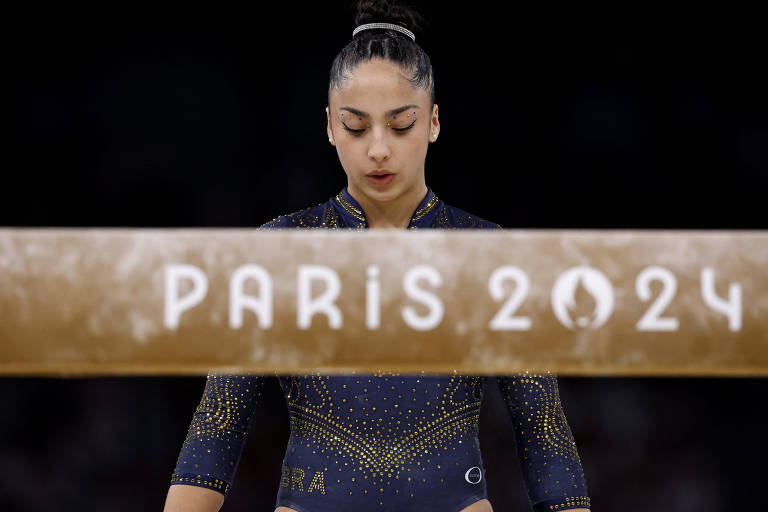 A brasileira Julia Soares, que caiu em sua apresentação na trave na final por equipes da ginástica artística nas Olimpíadas, baixa a cabeça diante do aparelho, que traz a inscrição "Paris 2024"