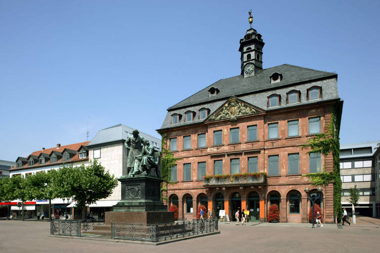 Monumento aos Irmãos Grimm em frente a prédio histórico na cidade de Hanau, na Alemanha