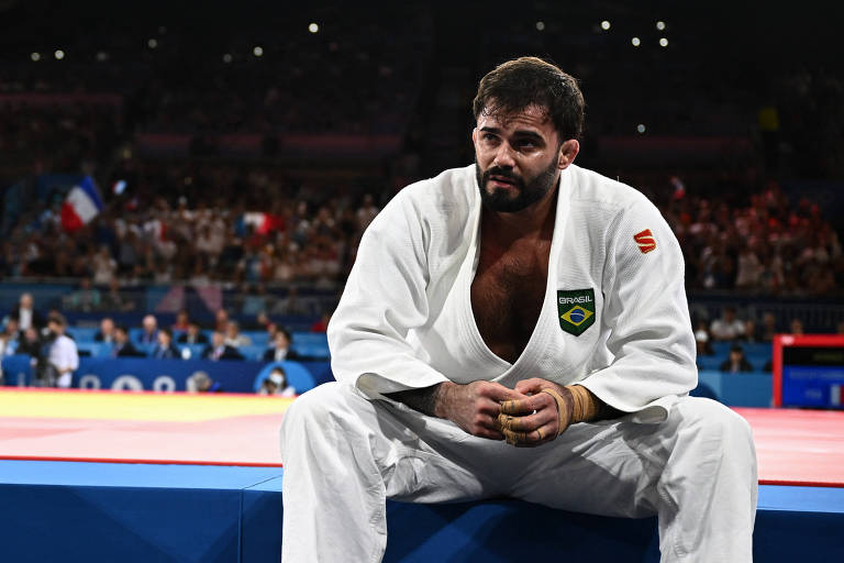 Usando quimono branco e sentado após a luta, o judoca Rafael Macedo lamenta derrota para o francês Maxime-Gael Ngaya na Arena do Campo de Marte, nas Olimpíadas de Paris