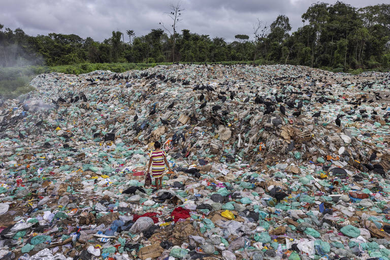 Maria Lopes Goncalves, 54, moradora de Breves (PA), procura por material reciclável no lixão da cidade