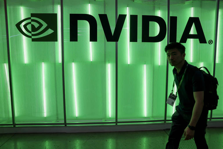 A imagem mostra um logotipo da NVIDIA em uma parede iluminada com luzes verdes. À frente do logotipo, há uma pessoa em silhueta, que parece estar se movendo. O ambiente é moderno e tecnológico.