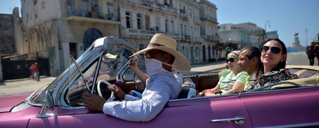 Táxi conduz turistas americanas por Havana, em Cuba