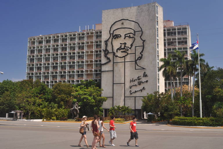 Turistas na praça da Revolução, em Havana, com a figura do líder revolucionário Che Guevara ao fundo