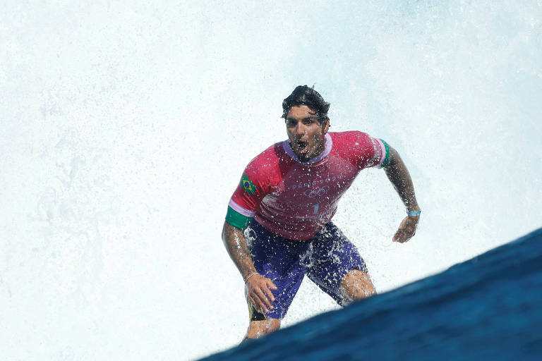 O brasileiro Gabriel Medina, como camiseta rosa, surfa em Teahupo'o, no Taiti, local do surfe em Paris-2024