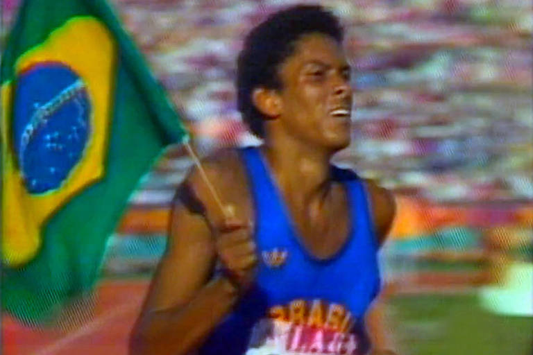 Joaquim Cruz segura bandeira do Brasil na volta olímpica após conquistar o ouro nos 800 m nas Olimpíadas de Los Angeles-1984