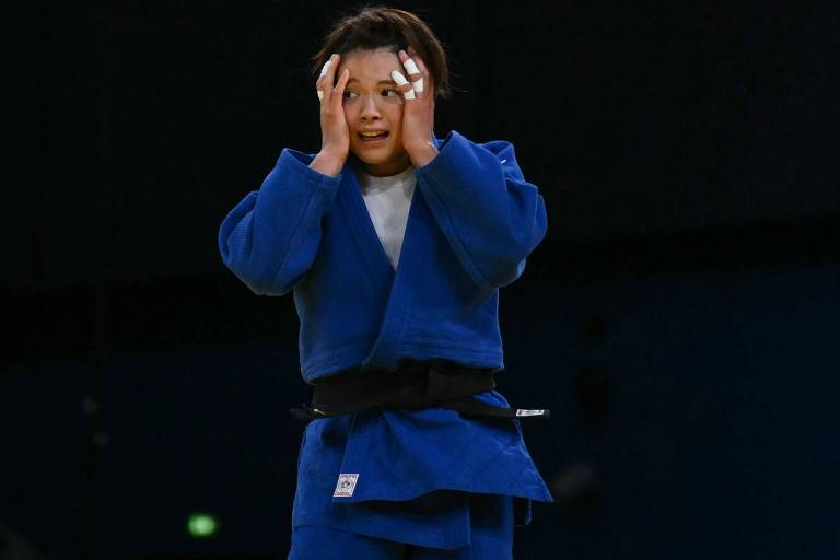 De quimono azul, a judoca japonesa Uta Abe, ouro em Tóquio-2020, se desespera ao perder sua luta nas oitavas de final em Paris-2024