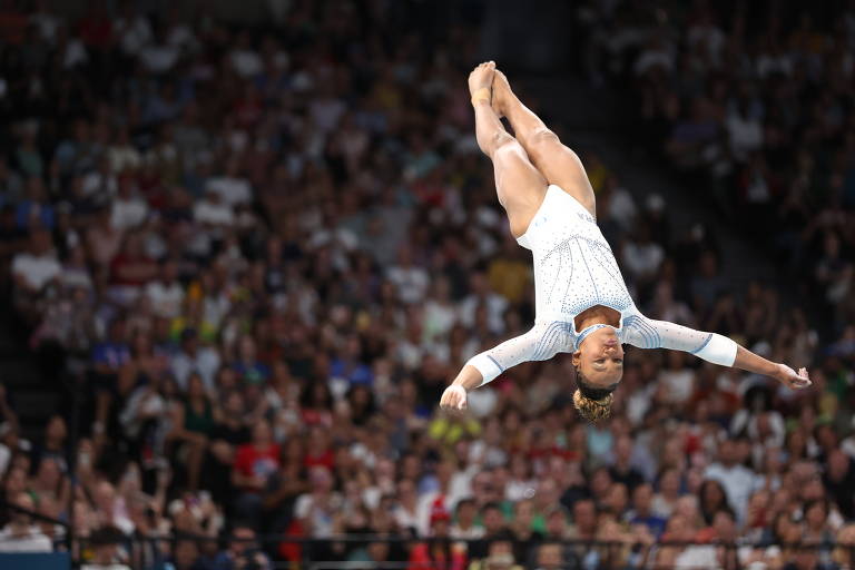 Ela abre os braços finalizando o salto