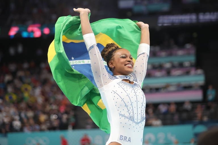 Rebeca com a bandeira brasileira comemora a prata conquistada na final de saltos