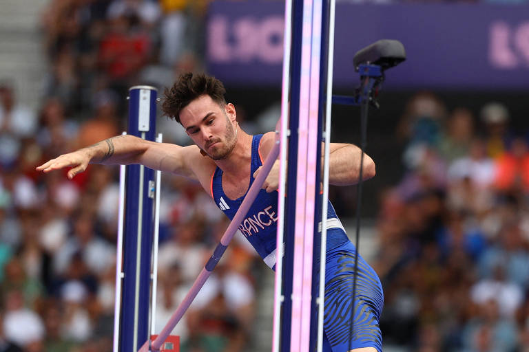 Foto mostra o atleta francês sobrevoando o sarrafo que mede a altura no salto com varas. Anthony Ammiratié um homem branco com barba por fazer e cabelos castanhos.